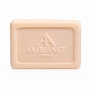 A pale pink bar of soap with embossed "Ancienne Ambiance London" decorative logo on the surface, set against a plain white background, conveying elegance.