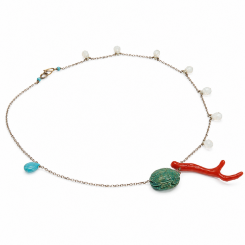 Delicate white gold chain necklace featuring small clear beads, a turquoise teardrop, a red branch-like charm, and an ancient Egyptian faience scarab centrepiece.