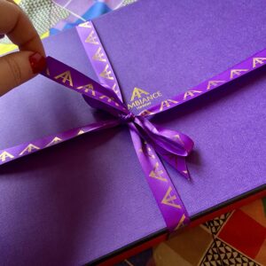 An iconic Ancienne Ambiance London purple gift box, tied up with signature purple satin and gold foil ribbon, is about to be unwrapped.