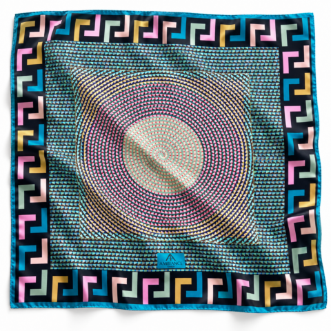 Colourful square silk scarf with geometric patterns. A central spiral in pink and beige contrasts with a bold blue border with Greek key design. Vibrant and dynamic.