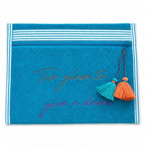 Blue towelling pouch bag with white stripes, featuring the phrase "Too glam to give a damn" in colourful script embroidery. Two tassels hanging on the right side convey a playful vibe.