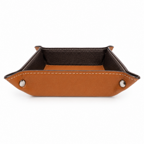 A square leather valet tray with a tan exterior and dark interior. The tray features stitched edges and snaps at each corner for structure.