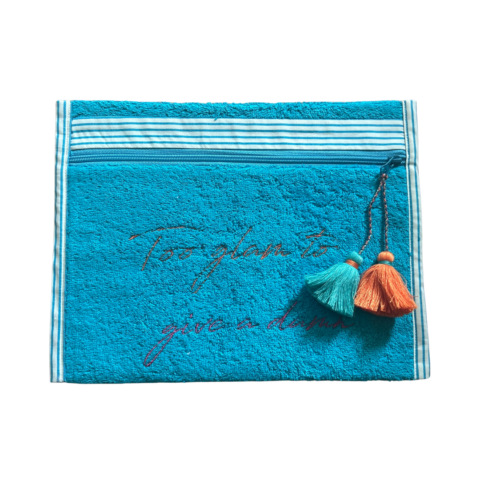 A blue towelling pouch with tassel zipper and embroidered with Too Glam To Give A Damn slogan.
