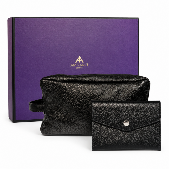 A textured black leather toiletry bag and wallet are displayed in front of a purple box with "Ancienne Ambiance London" logo. The scene conveys elegance and luxury.