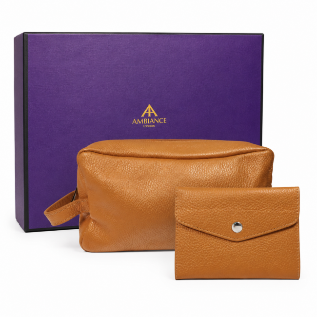 A tan leather pouch and wallet sit in front of a purple box with gold "Ancienne Ambiance London" logo. The image conveys luxury and elegance.