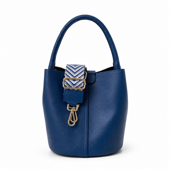 A stylish blue leather bucket bag with a curved handle and a detachable strap featuring a blue and white chevron pattern. Gold hardware accents add elegance.