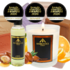 Award-winning Ancienne Ambiance London products: a scented candle, beauty oil and soaps. Accents include orange slices and argan, creating a warm, luxurious tone.