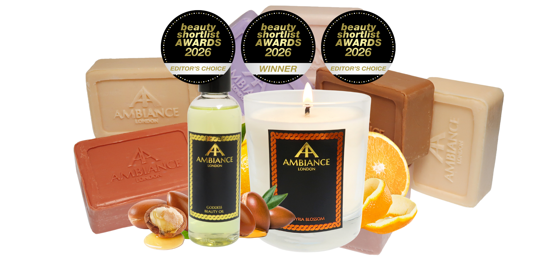 Award-winning Ancienne Ambiance London products: a scented candle, beauty oil and soaps. Accents include orange slices and argan, creating a warm, luxurious tone.