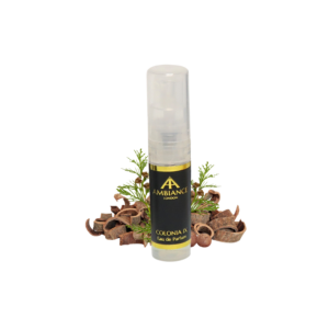 A sample perfume bottle labeled "Ancienne Ambiance London Colonia IX" stands among sandalwood shavings and cedar leaves, suggesting a natural, fresh scent.