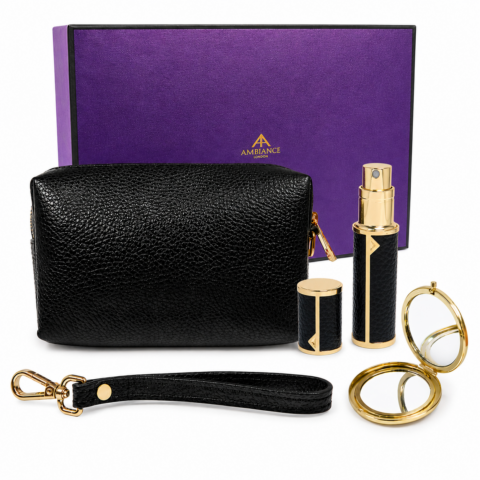 A luxurious black leather pouch set against a purple box. Includes a perfume atomizer, and compact mirror, all with gold accents.