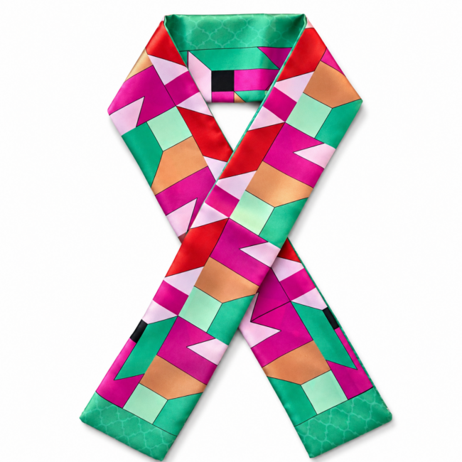 A vibrant silk twilly scarf with a geometric pattern featuring bold pink, red, green, and beige shapes. The design exudes a modern and energetic feel.