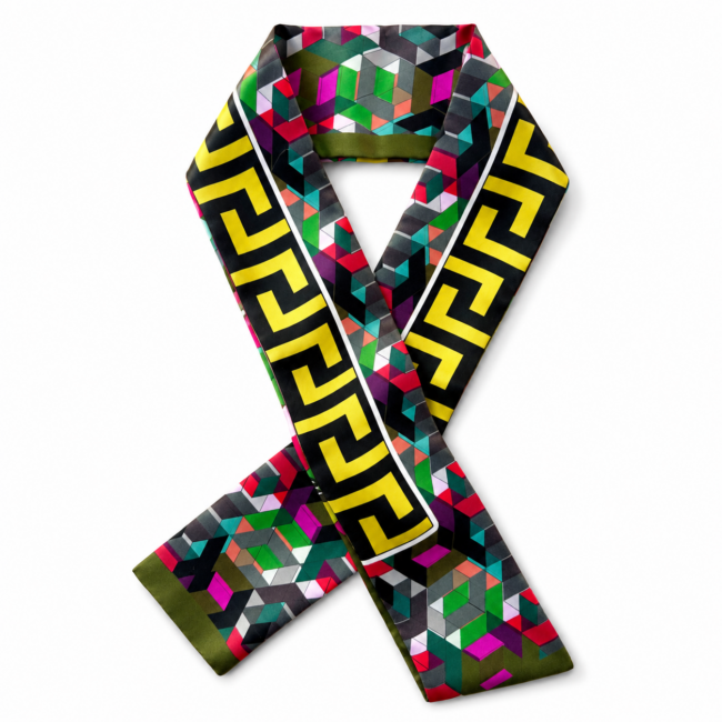 A colourful silk twilly scarf features a geometric pattern with vivid shades of green, pink, and red. Bold yellow Greek key motifs run along the edges.
