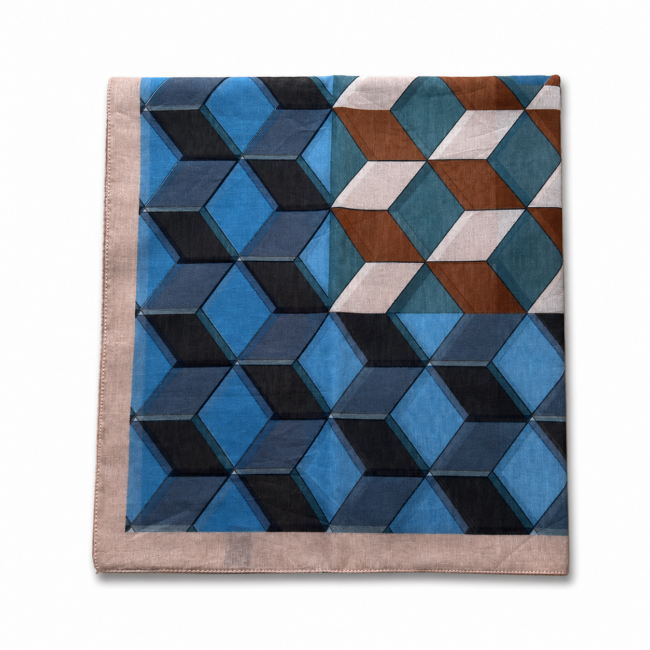 Folded geometric-patterned cotton silk scarf featuring blue, brown, and white 3D cubes on a beige border. The design is modern, intricate, and visually dynamic.