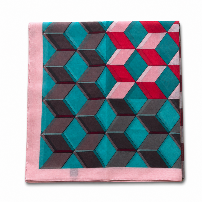 Folded geometric patterned cotton scarf with interlocking cubes in teal, pink, red, and black. It has a pink border, creating a vibrant, modern look.