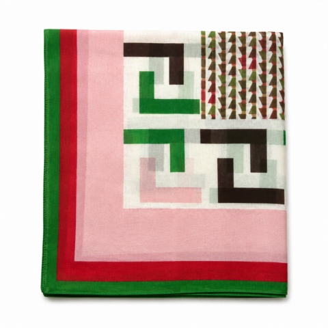 Folded cotton silk scarf with geometric patterns. Features green, red, black, and pink shapes on a white backdrop, bordered by green and red.