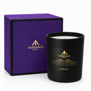 Black "Amarna Rose" candle with "Ancienne Ambiance London" label in gold next to an elegant purple box adorned with the same logo, evoking luxury and sophistication.