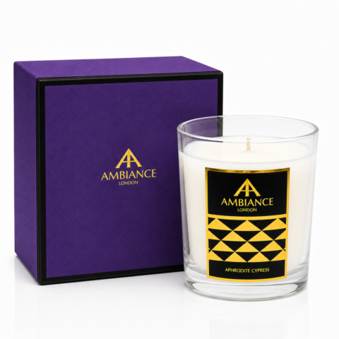 An Ancienne Ambiance London candle labeled "Aphrodite Cypress" with geometric design, next to a matching purple and black box. Elegant and luxurious presentation.