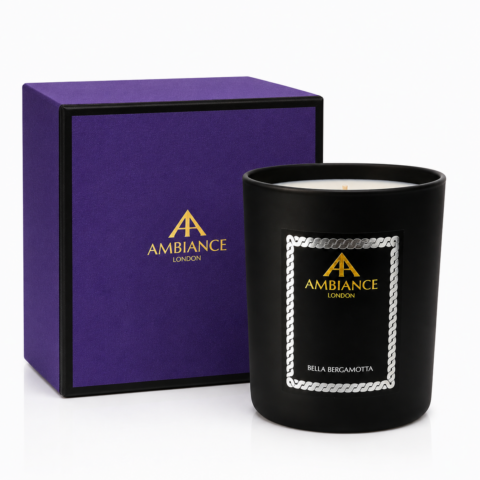 Black "Bella Bergamotta" luxury candle with "Ancienne Ambiance London" logo in gold, beside a purple box. The sleek design conveys elegance and sophistication.
