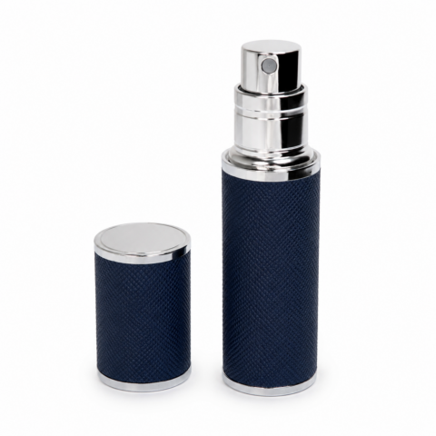 Sleek navy blue travel perfume atomiser with silver accents, featuring a textured surface, and a matching detachable cap beside it, on a white background.